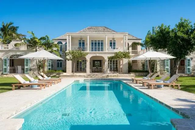 Sample photo: a large villa behind a long pool with parasols